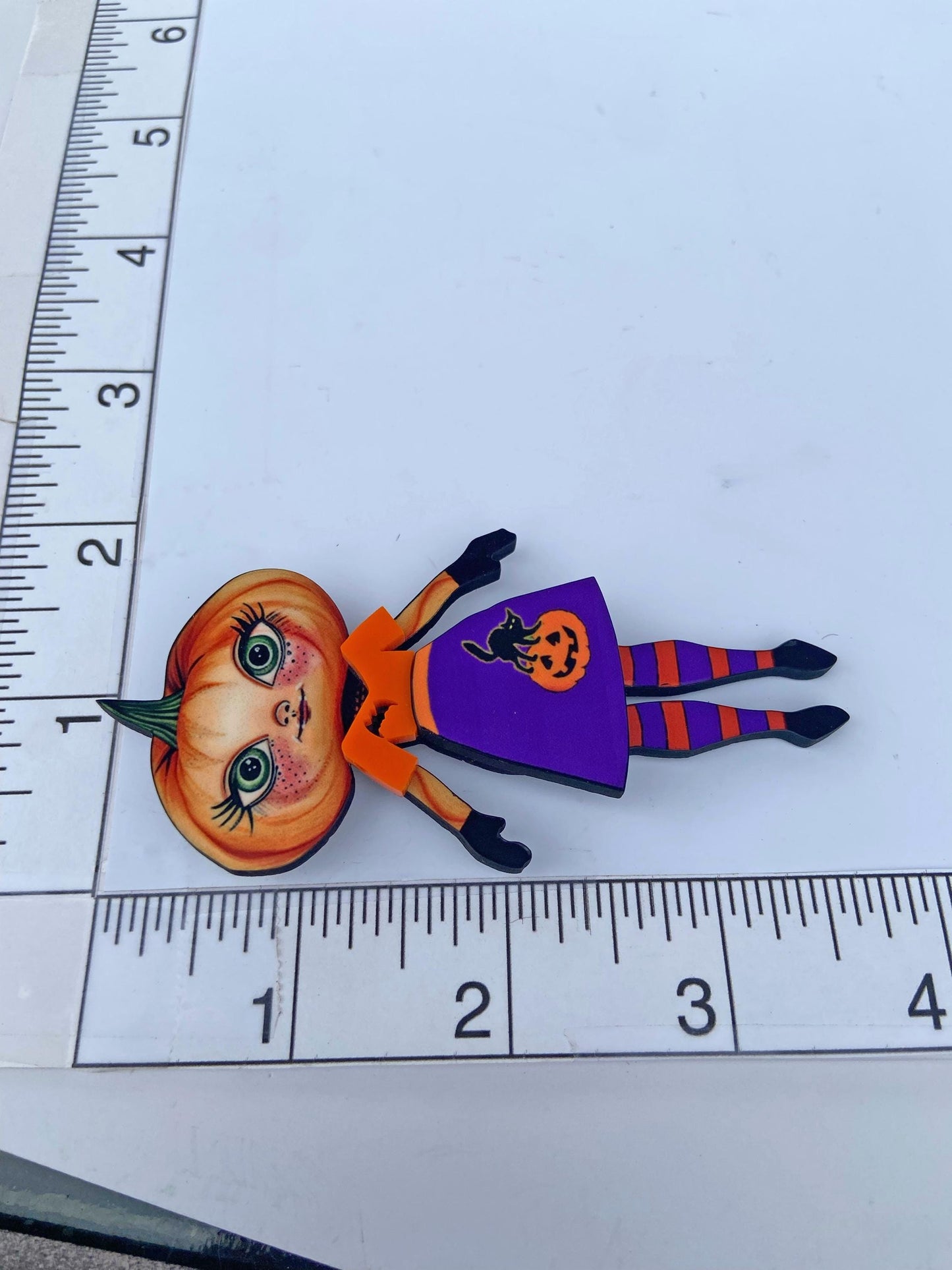 Pumpkin Girl Fall Halloween Brooch ~ Whimsical Autumn Design. Her outfit is adorned with a pumpkin, a black cat, and a bat. Handmade