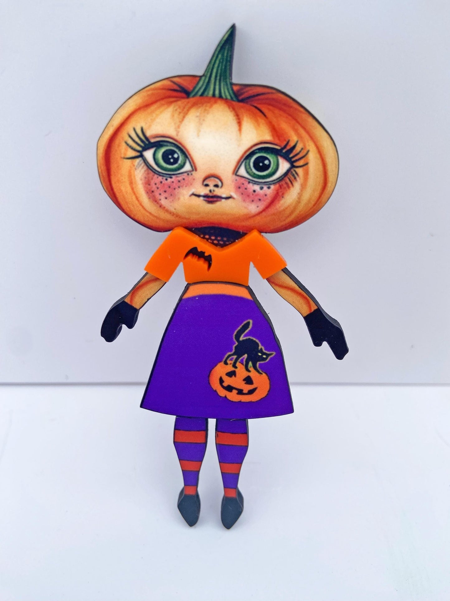 Pumpkin Girl Fall Halloween Brooch ~ Whimsical Autumn Design. Her outfit is adorned with a pumpkin, a black cat, and a bat. Handmade